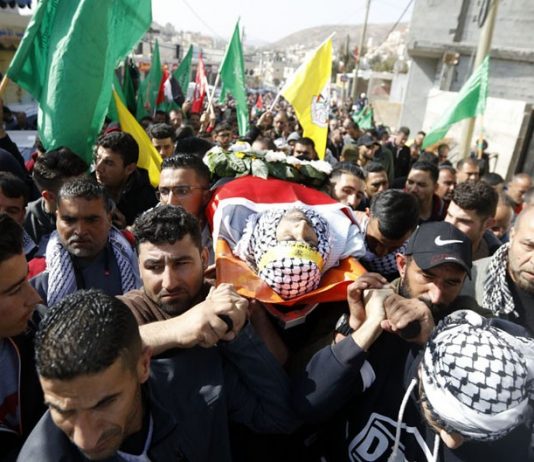 The body of Hamdi Nassan from the village of al-Mughayir, who was shot dead by Israeli settlers, is carried to his last resting place