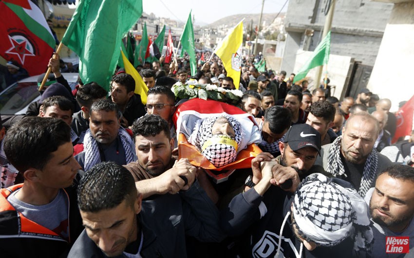 The body of Hamdi Nassan from the village of al-Mughayir, who was shot dead by Israeli settlers, is carried to his last resting place