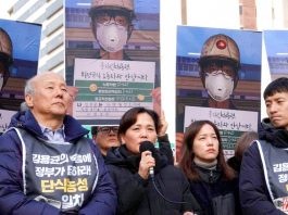 Kim’s mother speaking at a rally in front of pictures of her son taken just before his death at work