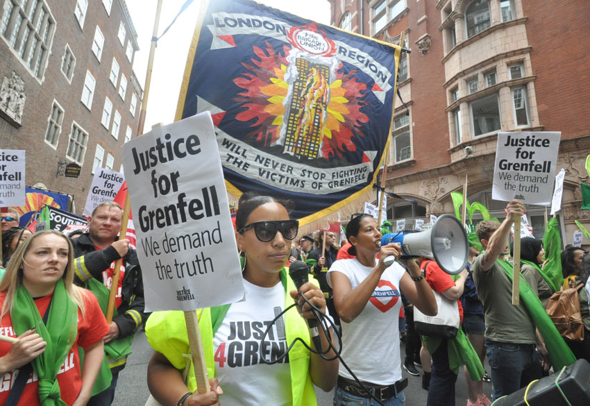 Firefighters march with survivors and local residents on the first anniversary of the Grenfell inferno